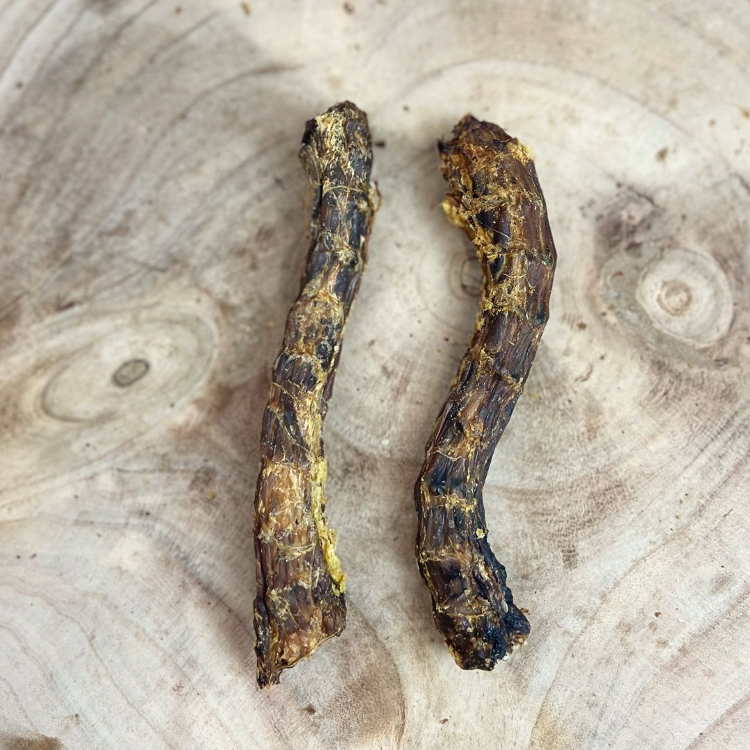 Two all natural dried duck necks on a wooden backgorund