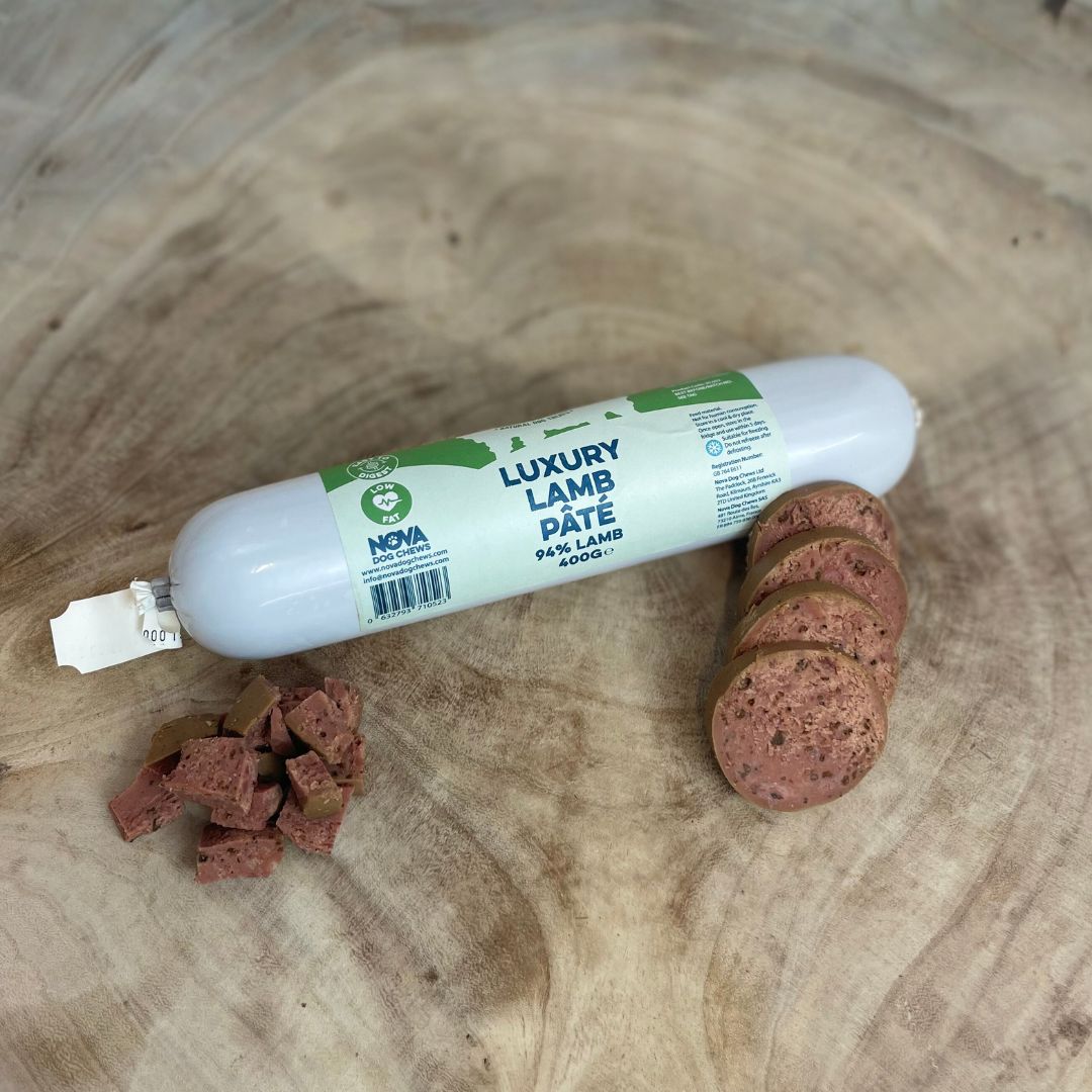 All natural luxury lamb pate in a tube with sliced and diced sections in front on a wooden background