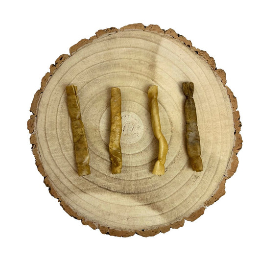 Four all natural dried buffalo collagen sticks on a wooden background
