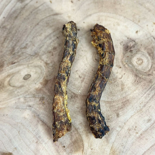 Two all natural dried duck necks on a wooden backgorund