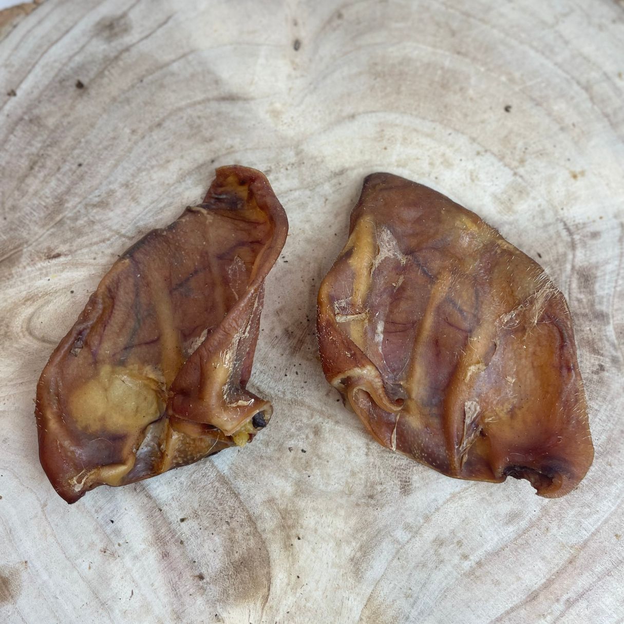 All natural dried large pigs ears on a wooden background
