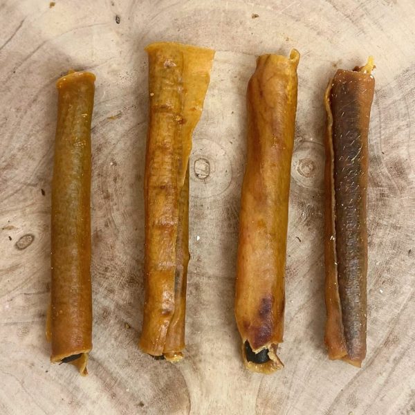 Four all natural dried large sausage rolls on a wooden background 