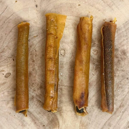 Four all natural dried large sausage rolls on a wooden background 