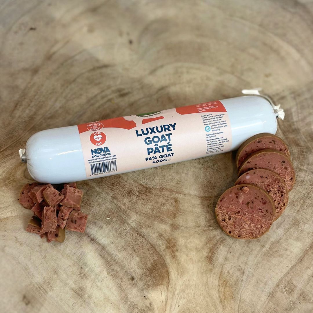 All natural luxury goat pate in a tube with slices and diced cubes in front on a wooden backround