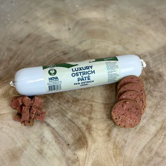 All natural luxury Ostrich pate in packet with cut discs and cubes in front on a wooden background 