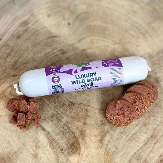 All natural luxury wild boar pate in a tube with slices and diced cubes in front on a wooden background