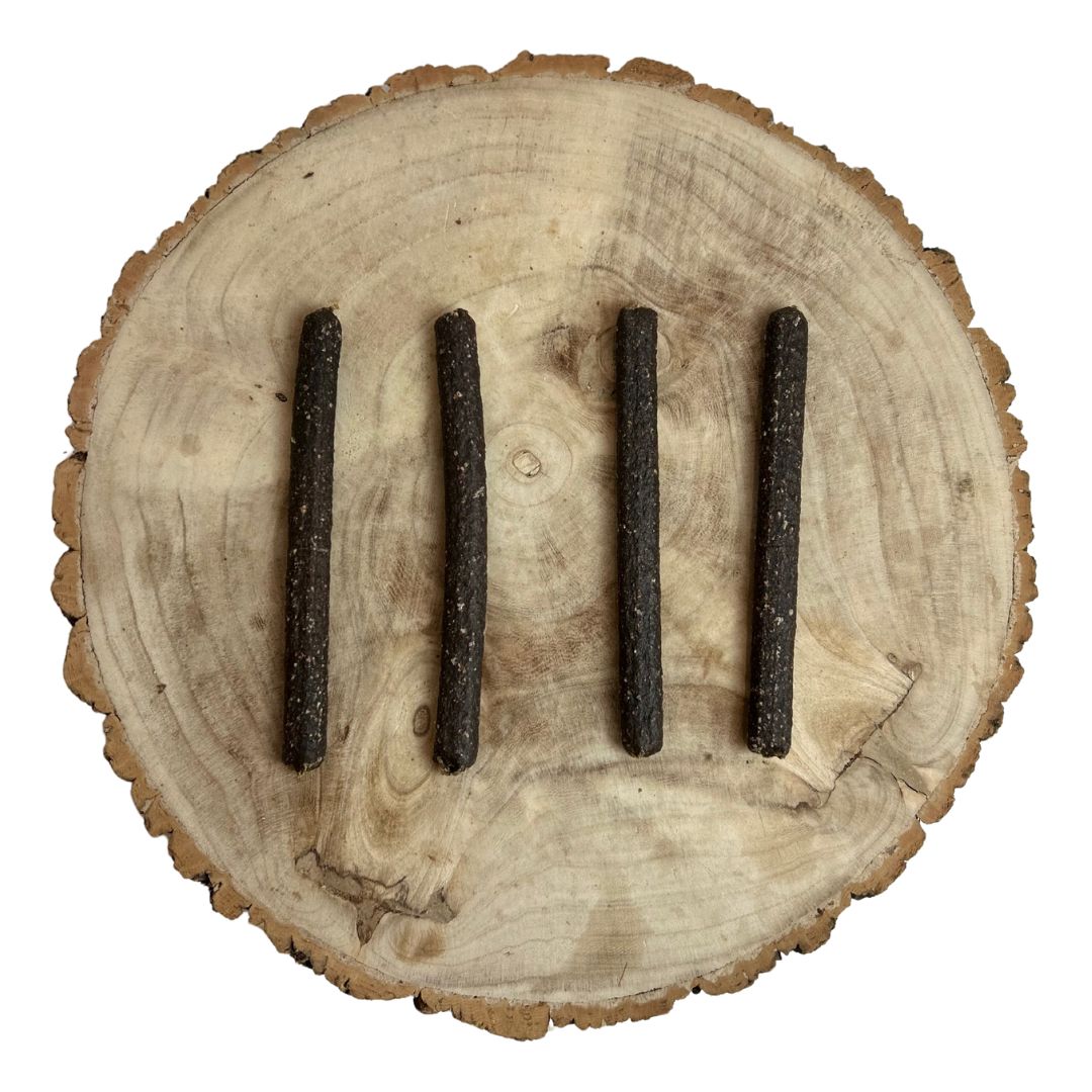 Four all natural dried venison meaty sticks on a wooden background